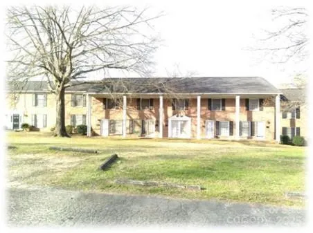 a front view of a house with a yard and trees
