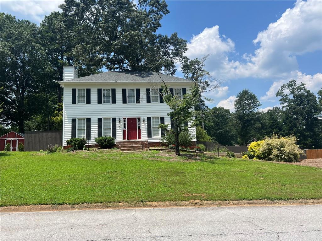 a view of a house with a yard and sitting area