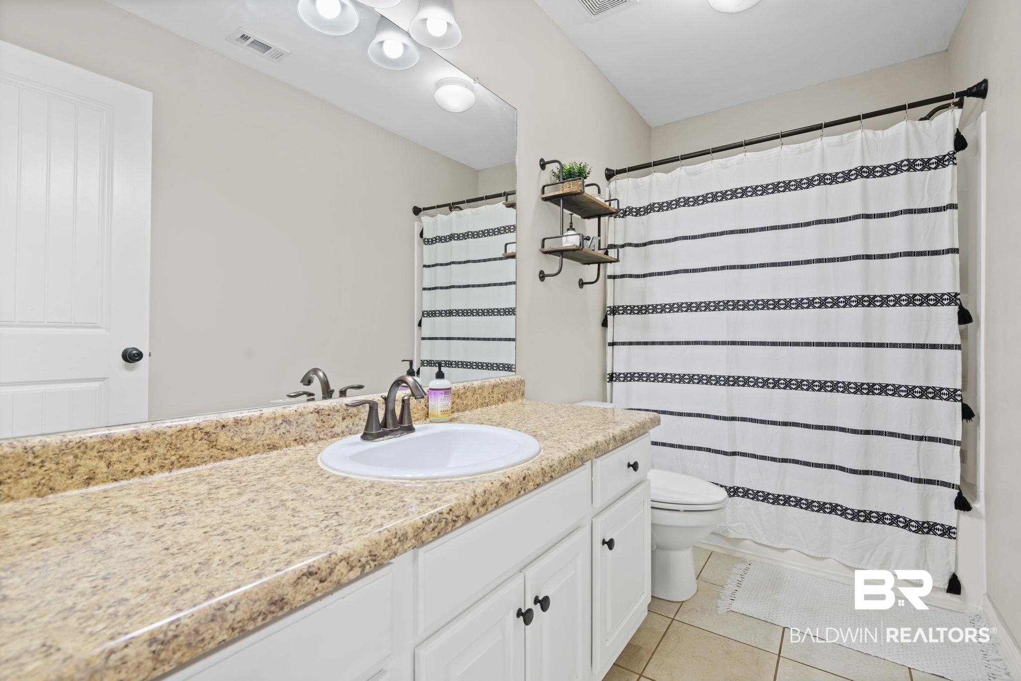 8956 Spring Grove North Mobile, AL 36695 - Photo 11 of 19 Full bath with vanity, tile patterned flooring, toilet, and a shower with shower curtain