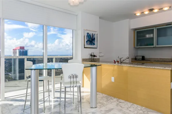 a view of a kitchen with a floor to ceiling window and an outdoor space