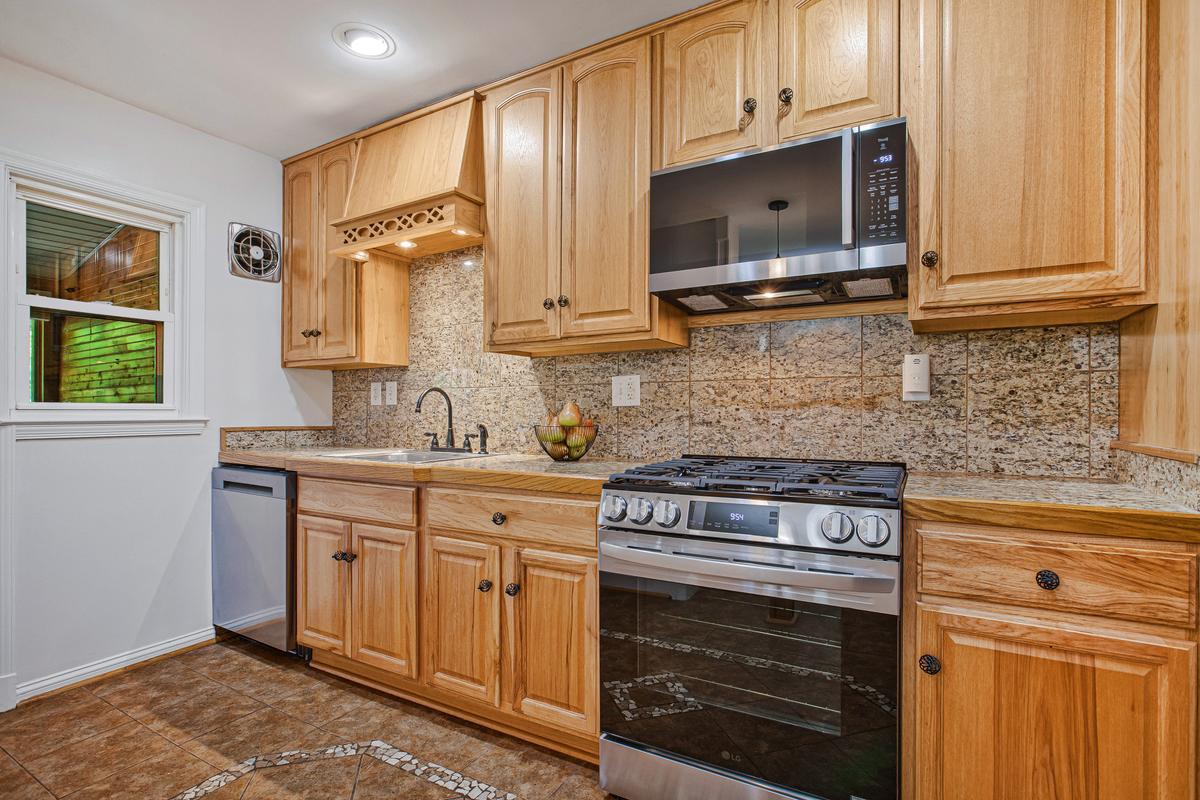 1016 Winsford Road Towson, MD 21204 - Photo 11 of 42 a kitchen with stainless steel appliances granite countertop a stove a sink and a microwave