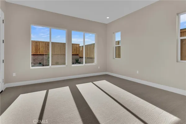 a view of a bedroom with wooden floor and windows
