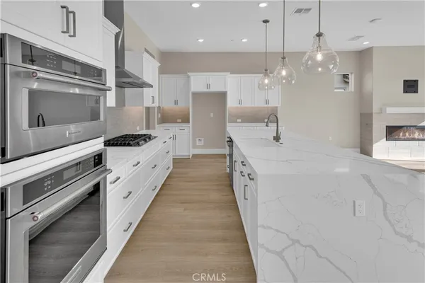 a large kitchen with stainless steel appliances kitchen island granite countertop a stove a sink and a refrigerator