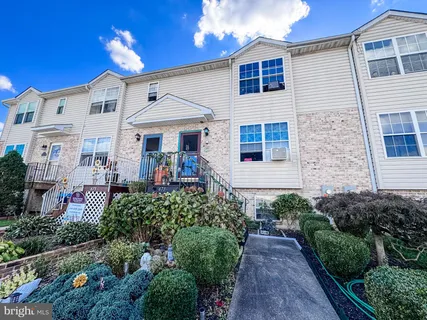 a view of a house with potted plants and a table and chair