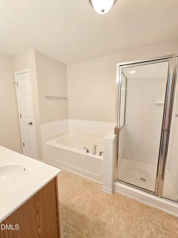 a spacious bathroom with a tub sink and mirror