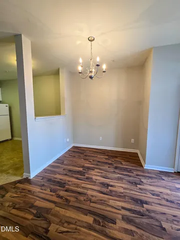 a view of a room with wooden floor and chandelier