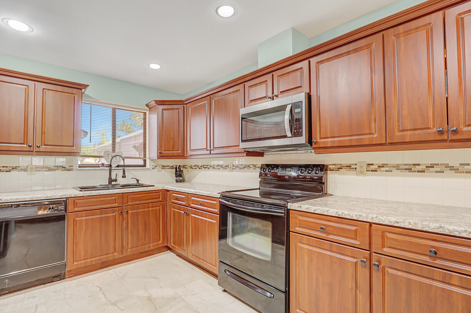 6148 Southeast Georgetown Place, Unit 805 Hobe Sound, FL 33455 - Photo 12 of 44 a kitchen with granite countertop cabinets stainless steel appliances and a sink