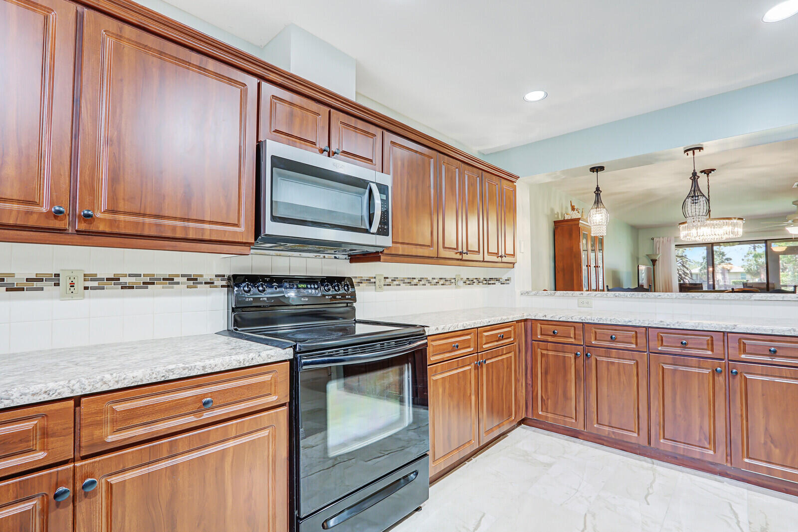 6148 Southeast Georgetown Place, Unit 805 Hobe Sound, FL 33455 - Photo 14 of 44 a kitchen with granite countertop cabinets stainless steel appliances and a counter space