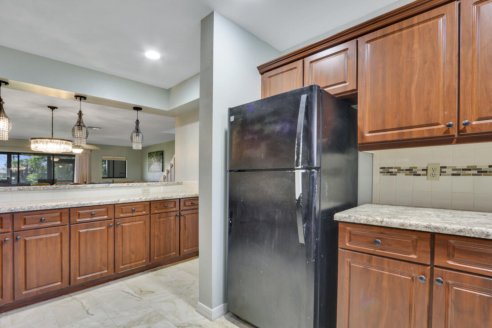 6148 Southeast Georgetown Place, Unit 805 Hobe Sound, FL 33455 - Photo 15 of 44 a kitchen with stainless steel appliances granite countertop a refrigerator and a sink