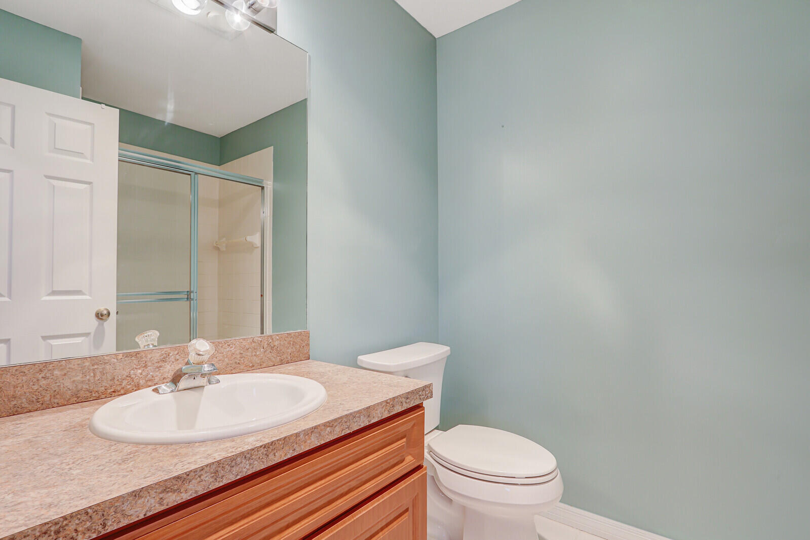 6148 Southeast Georgetown Place, Unit 805 Hobe Sound, FL 33455 - Photo 38 of 44 a bathroom with a granite countertop sink a toilet and a mirror