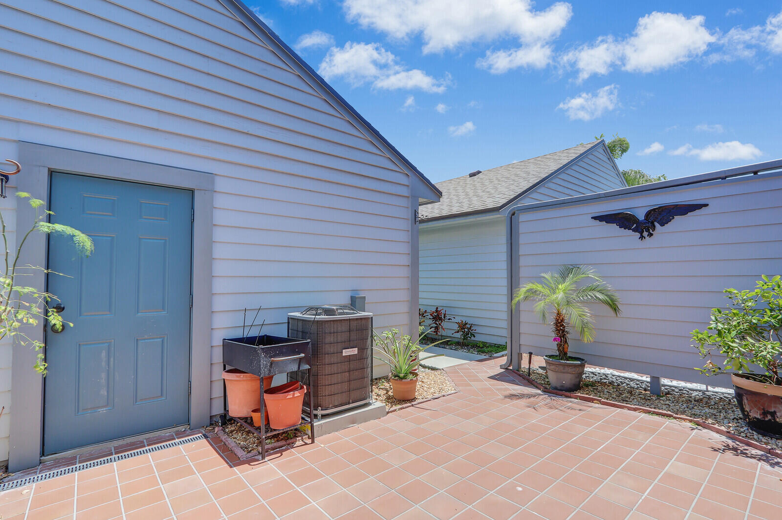 6148 Southeast Georgetown Place, Unit 805 Hobe Sound, FL 33455 - Photo 6 of 44 a view of a patio with table and chairs and potted plants