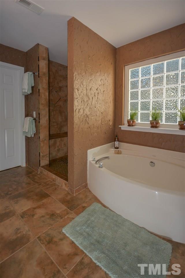 8502 Pillar Gate Lane Raleigh, NC 27613 - Photo 14 of 22 a bathroom with a bathtub and a shower