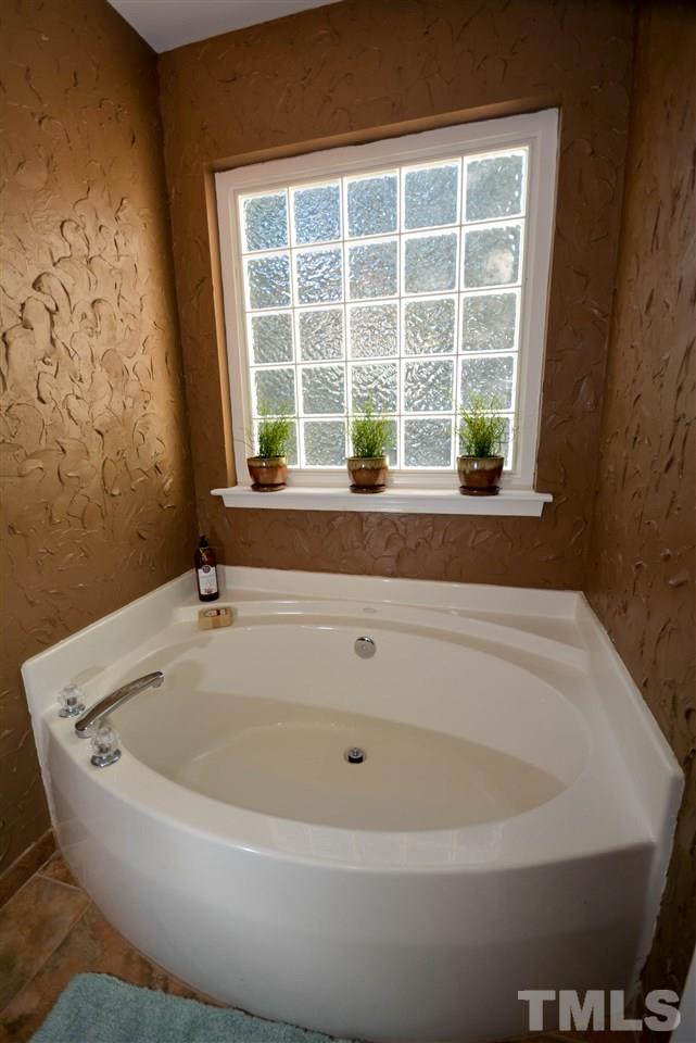 8502 Pillar Gate Lane Raleigh, NC 27613 - Photo 15 of 22 a white bath tub sitting in a bathroom next to a window