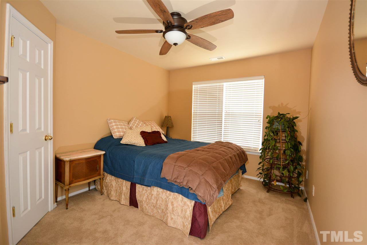 8502 Pillar Gate Lane Raleigh, NC 27613 - Photo 18 of 22 a bedroom with a bed and a chandelier