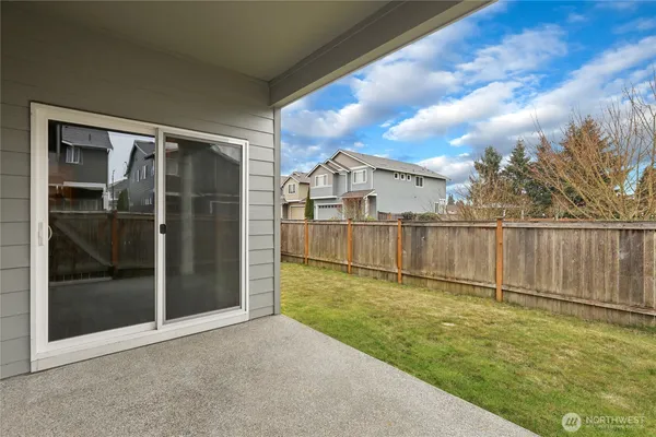 a view of backyard with barbeque grill and wooden fence