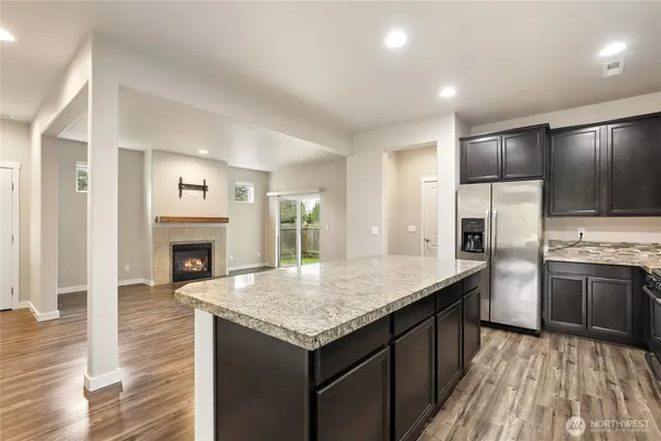 a kitchen with granite countertop kitchen island a sink stove and refrigerator