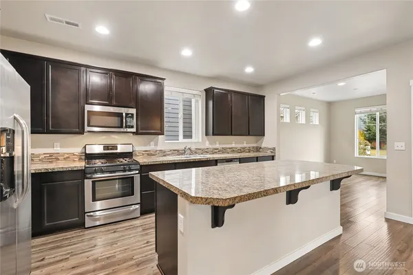 a kitchen with stainless steel appliances granite countertop a sink stove and oven