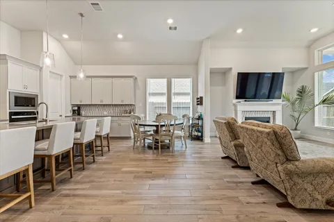 a living room with stainless steel appliances furniture and a flat screen tv
