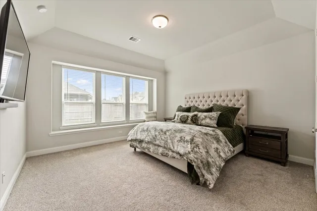a bed sitting in a bedroom next to a window
