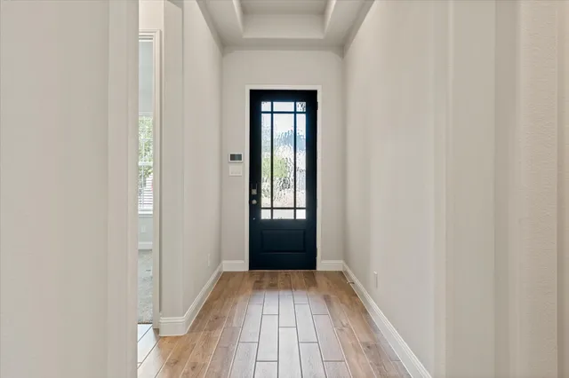 a view of a hallway with wooden floor