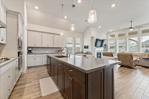 a kitchen with kitchen island granite countertop a sink counter top space appliances and cabinets