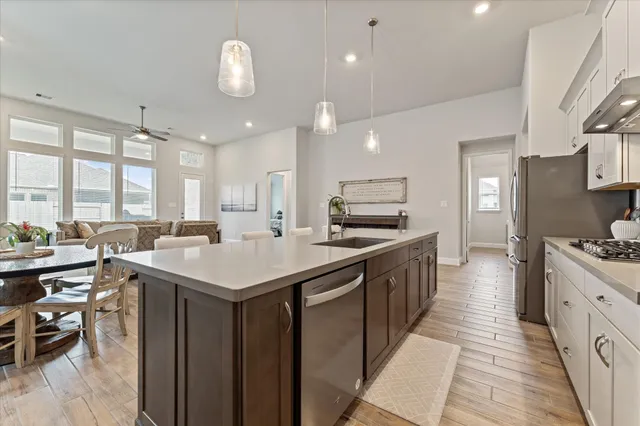 a kitchen with lots of counter space a sink appliances and a large window