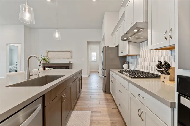 a kitchen with stainless steel appliances a sink stove and cabinets