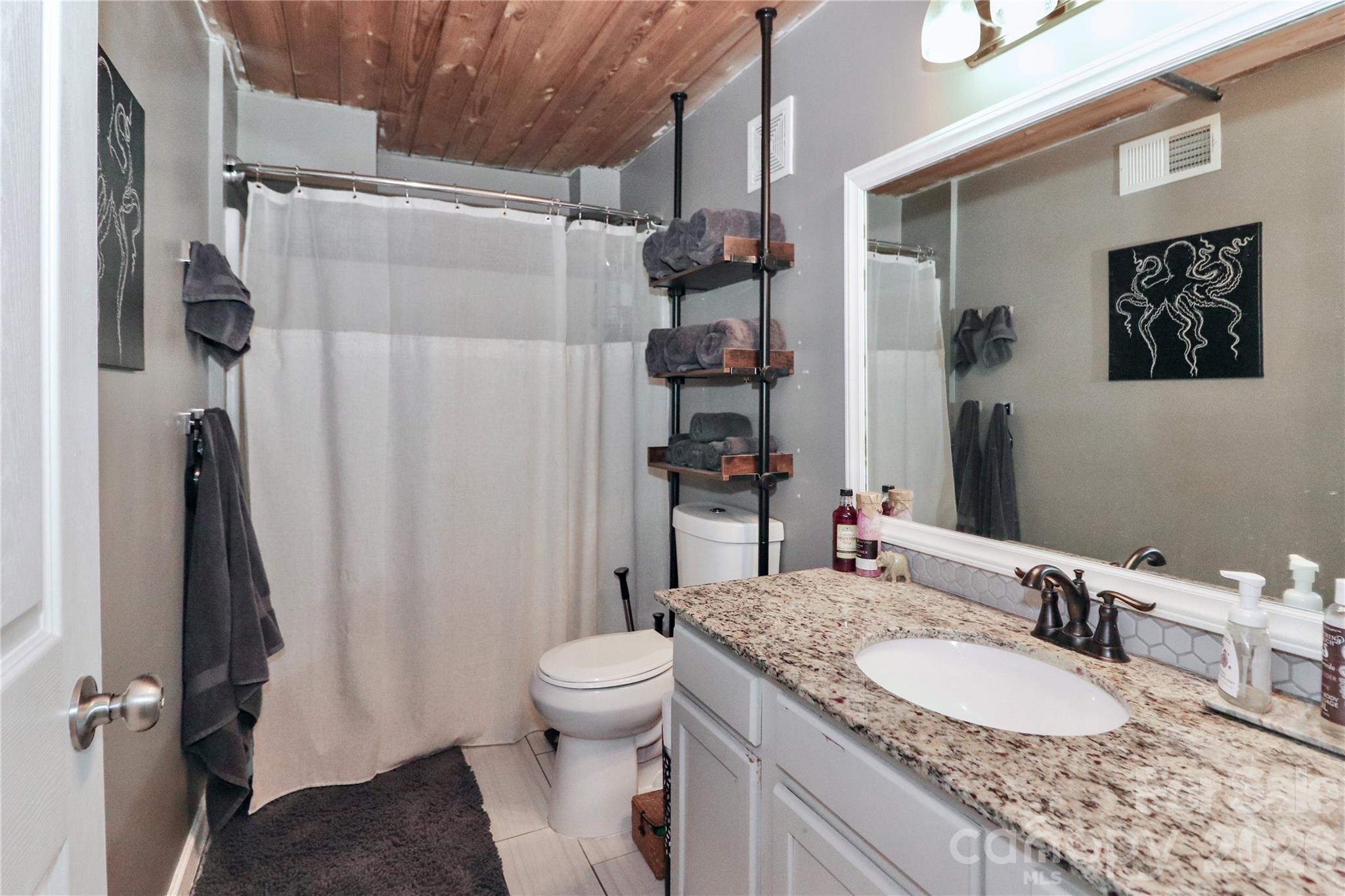 201 South Hoskins Road, Unit 315 Charlotte, NC 28208 - Photo 11 of 40 a bathroom with a granite countertop sink toilet and shower