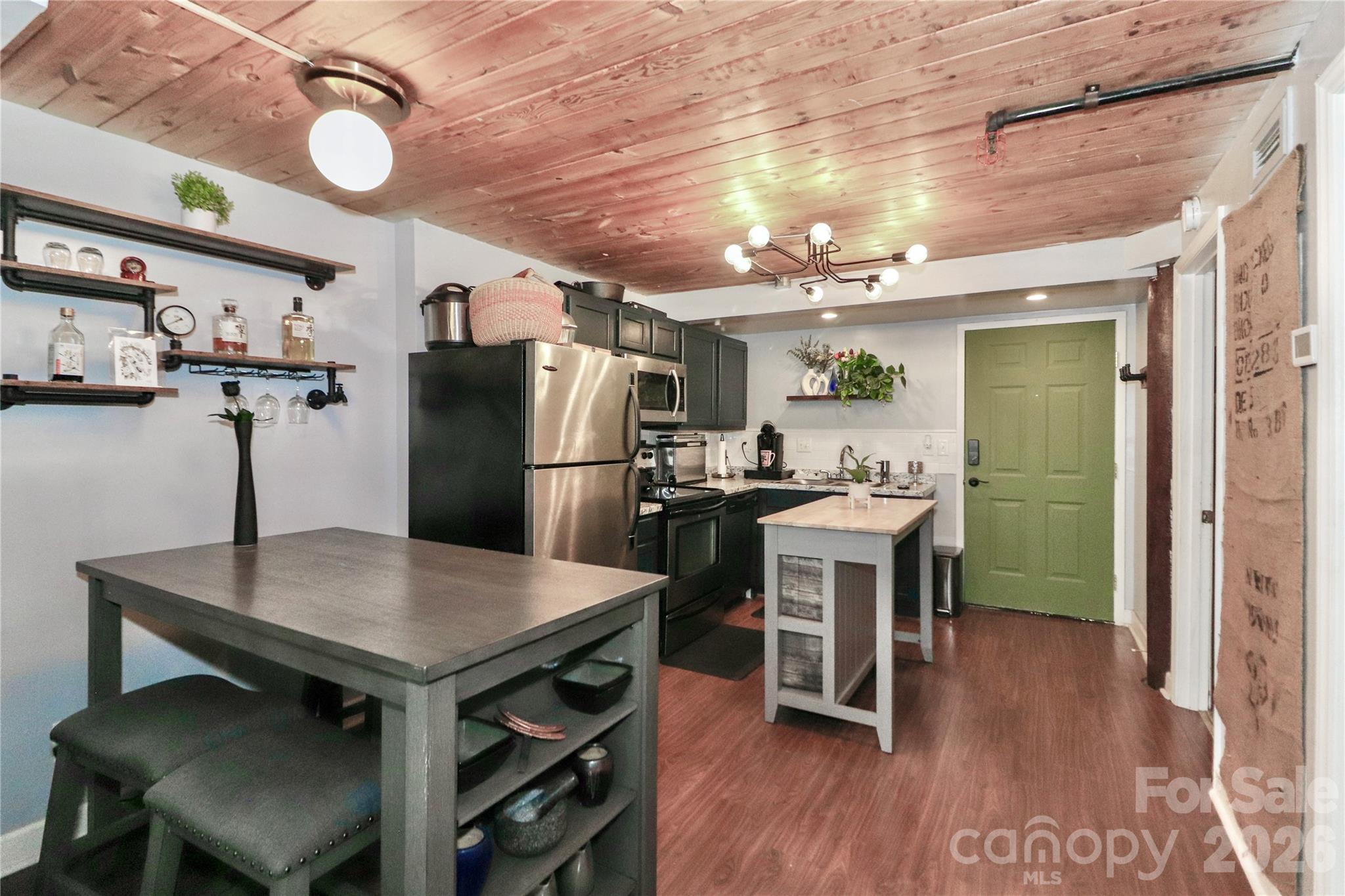 201 South Hoskins Road, Unit 315 Charlotte, NC 28208 - Photo 5 of 45 a kitchen with kitchen island a wooden floor and refrigerator