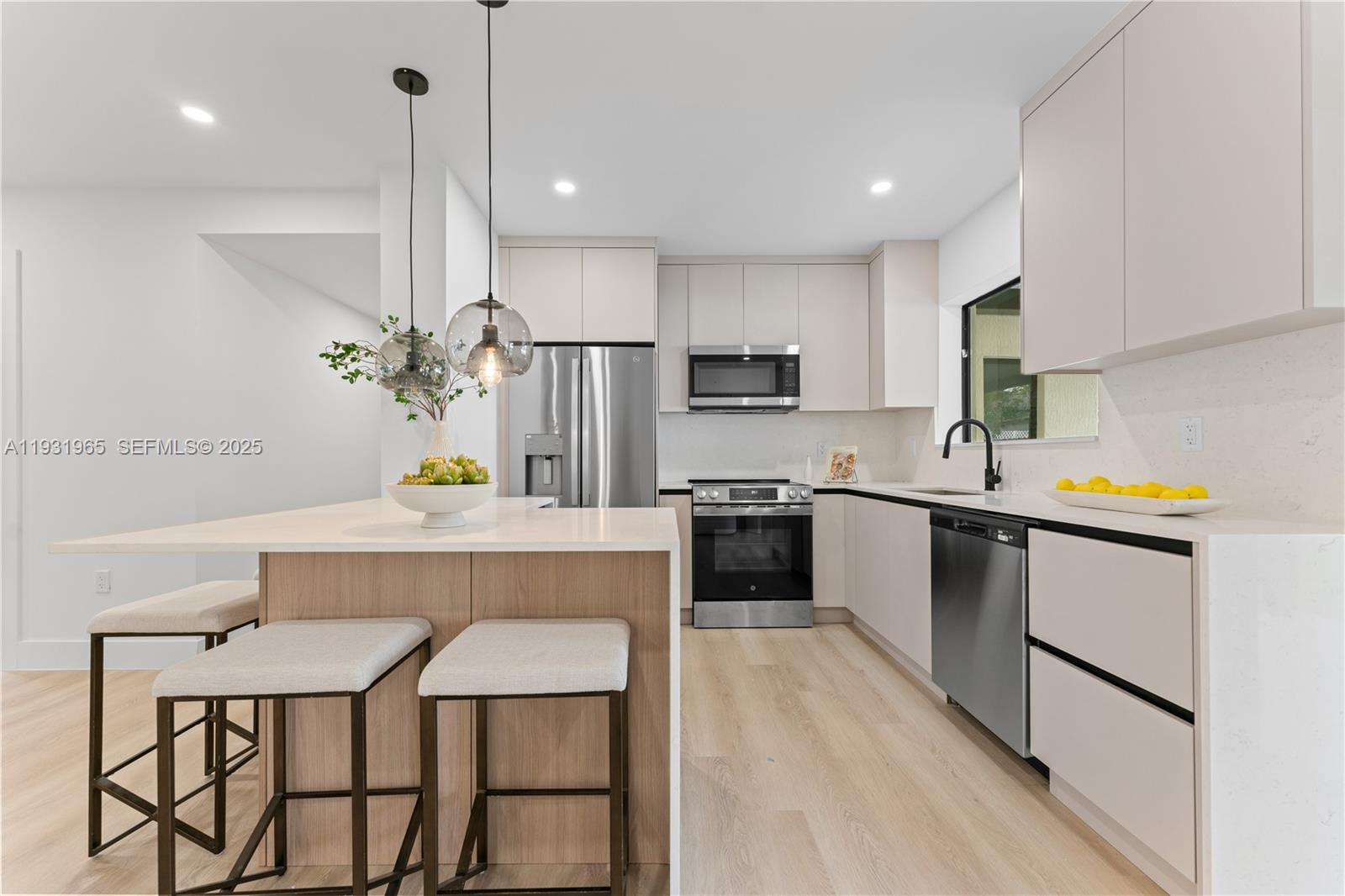 4555 Southwest 2nd Street Miami, FL 33134 - Photo 11 of 37 a kitchen with a sink a center island stainless steel appliances and cabinets
