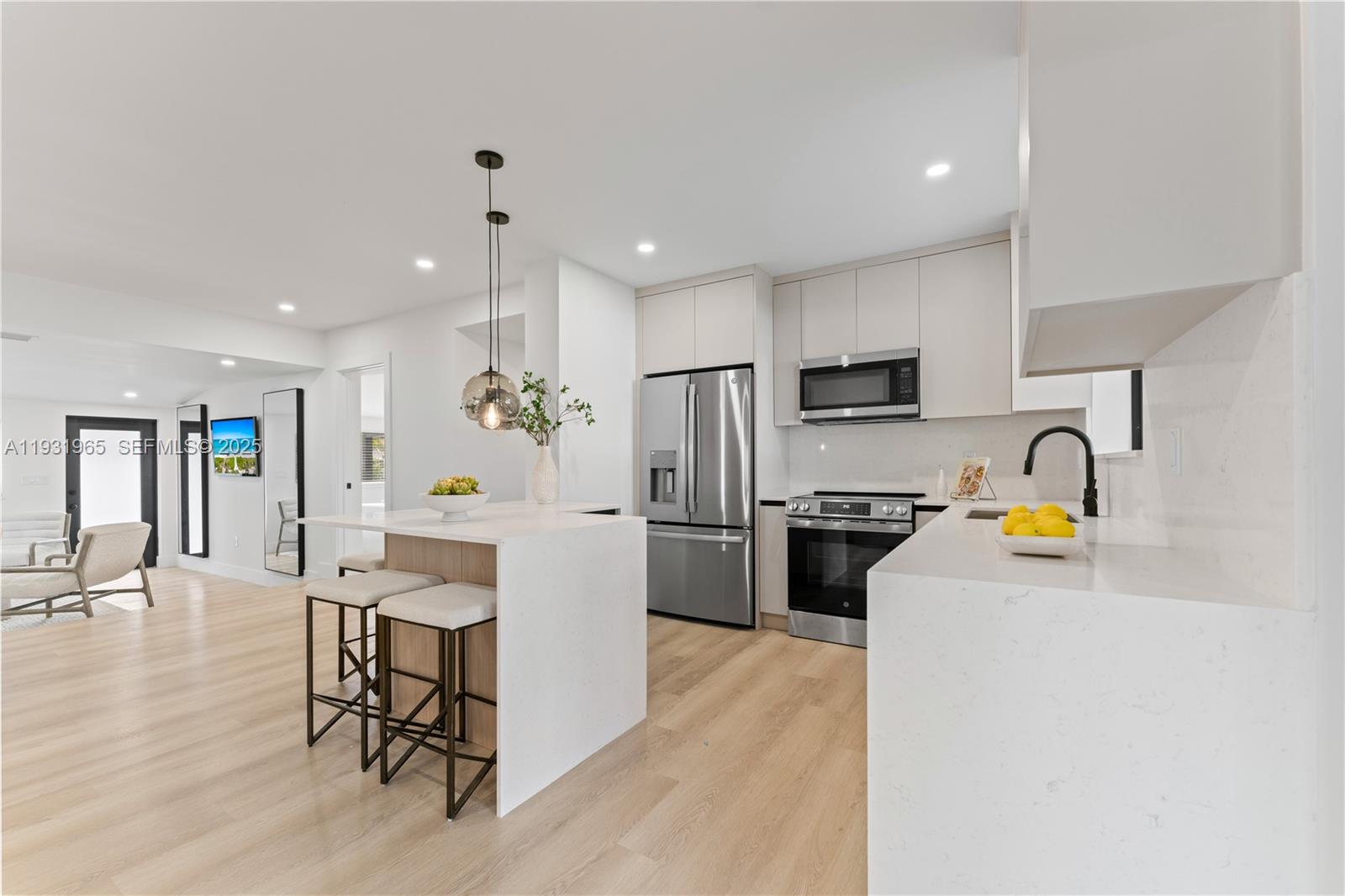 4555 Southwest 2nd Street Miami, FL 33134 - Photo 9 of 37 a kitchen with a refrigerator a stove top oven a sink dishwasher and white cabinets with wooden floor