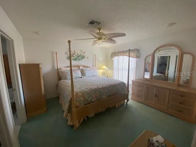 a bedroom with a bed a dresser and window