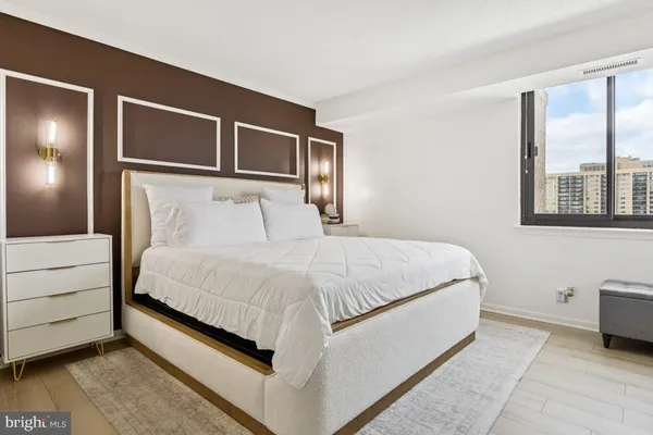 a large bed sitting in a bedroom next to a window