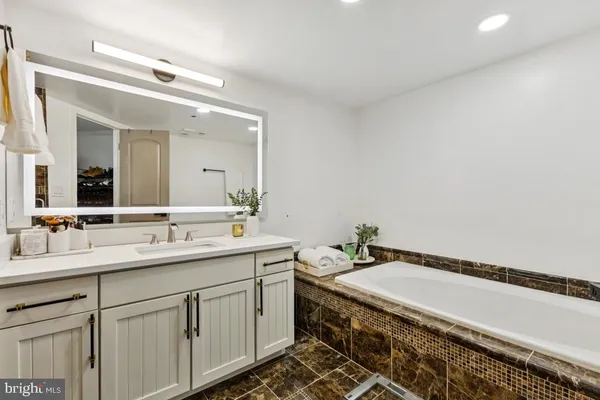a bathroom with a granite countertop sink and a mirror