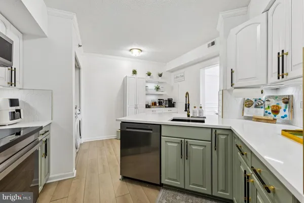 a kitchen with a sink cabinets and stainless steel appliances