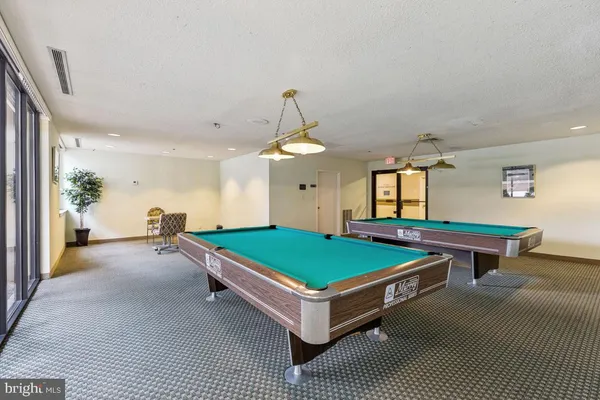 a room with pool table and windows