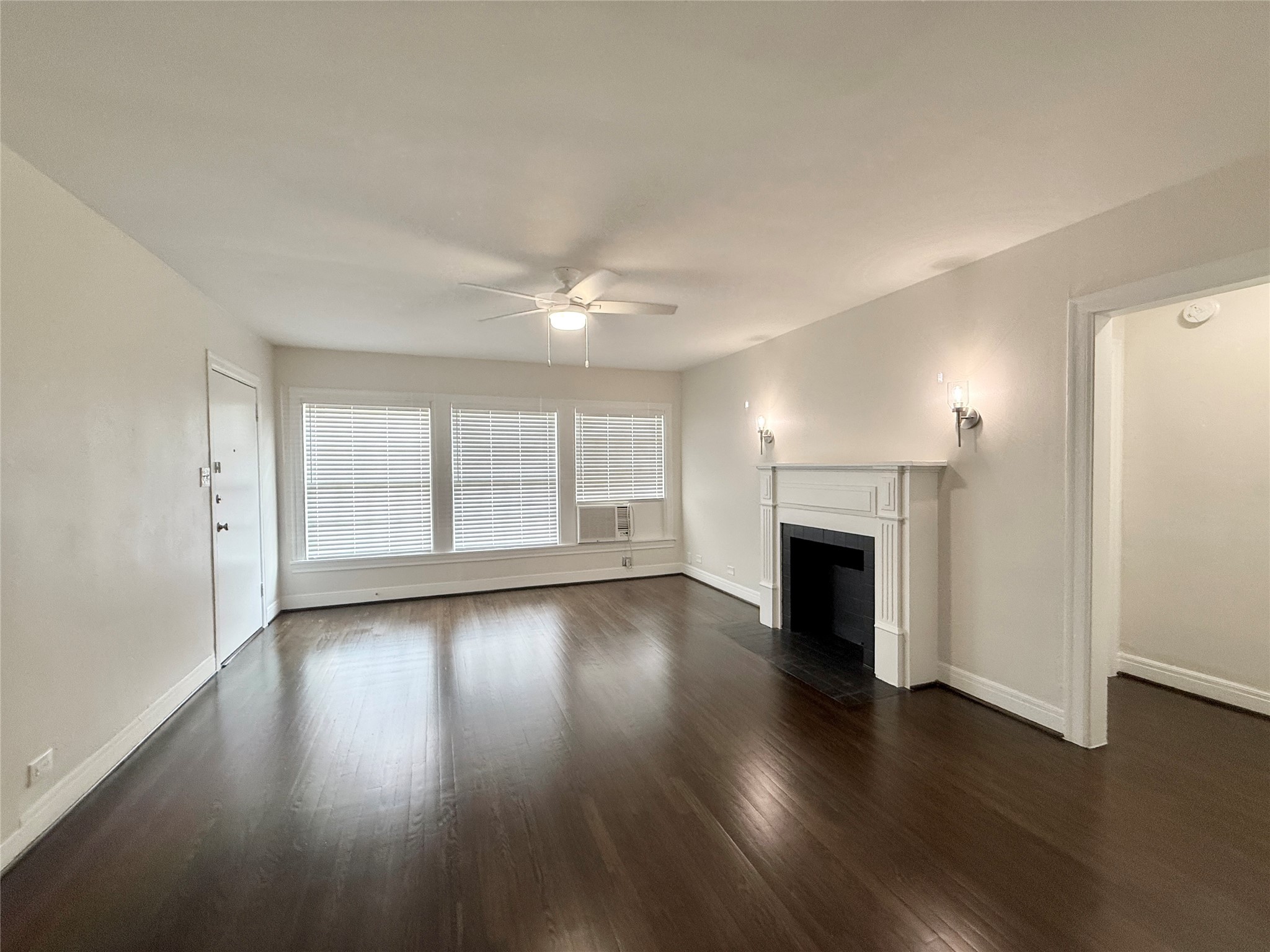 5402 Jackson Street, Unit 1 Houston, TX 77004 - Photo 3 of 18 an empty room with wooden floor fireplace and windows