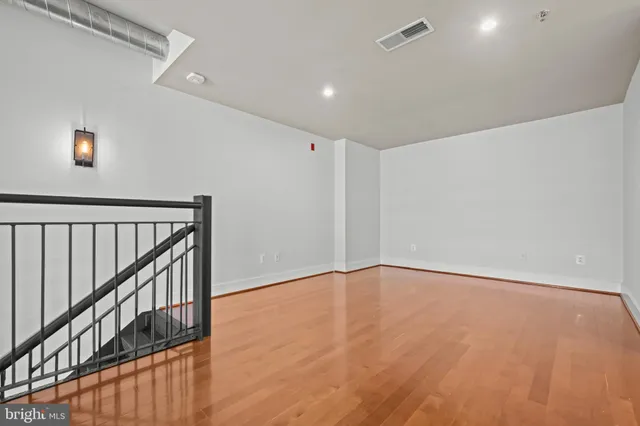a view of an empty room with wooden floor