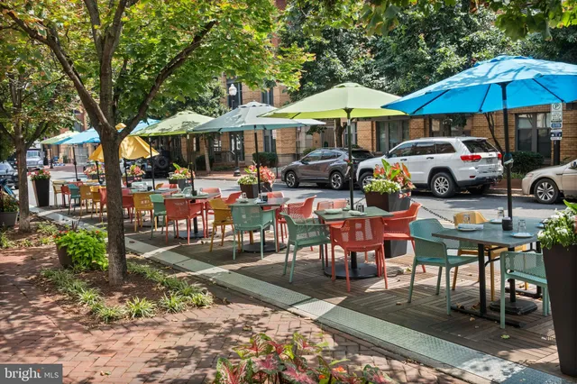a view of a house with a large window and wooden chairs