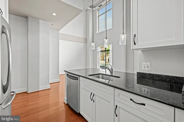 a kitchen with granite countertop white cabinets and white appliances