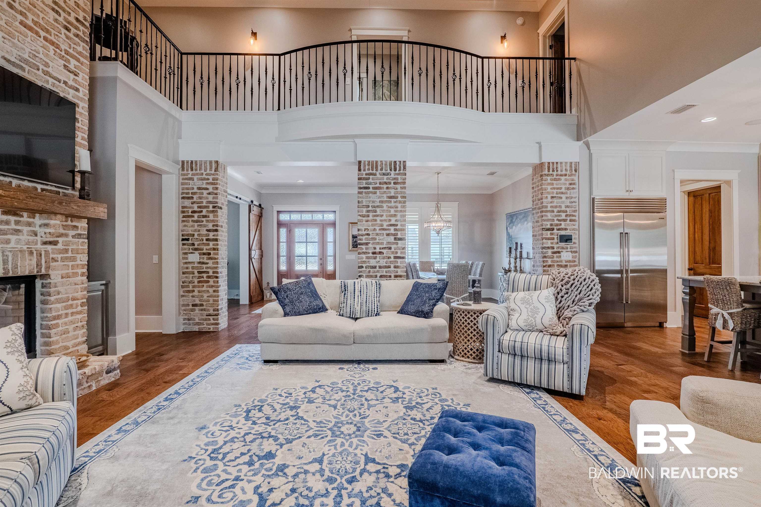 708 Manning Place Fairhope, AL 36532 - Photo 20 of 58 Living room with ornate columns, ornamental molding, a brick fireplace, and hardwood / wood-style floors