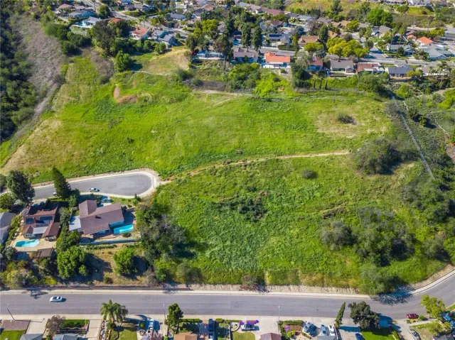 an aerial view of residential houses with outdoor space and trees