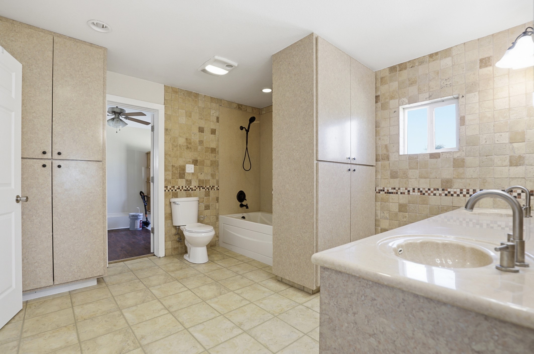 128 Skyview Terrace Leander, TX 78641 - Photo 14 of 23 Primary bathroom, is a full bath featuring a double vanity, tile walls, shower/washtub combination, and light tile patterned flooring