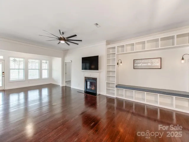 a view of a livingroom with wooden floor and a ceiling fan