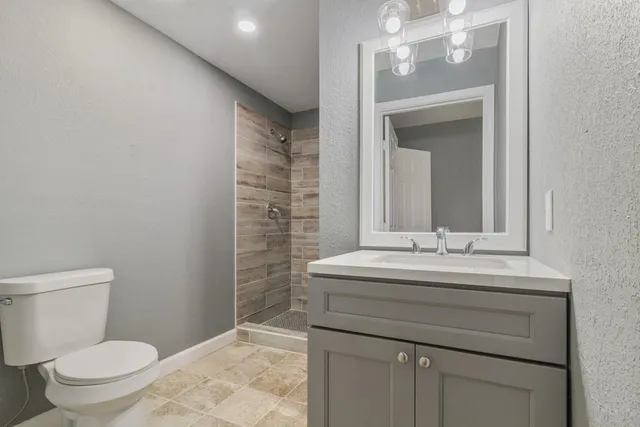 a bathroom with a sink a toilet and mirror