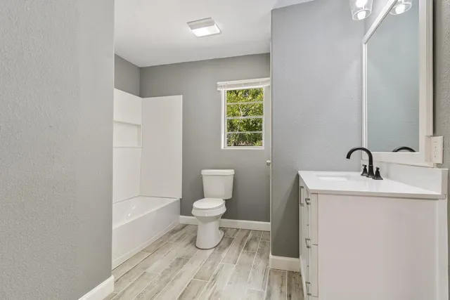 a bathroom with a toilet a sink and mirror