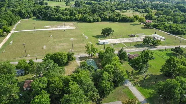 an aerial view of a residential houses with outdoor space and street view