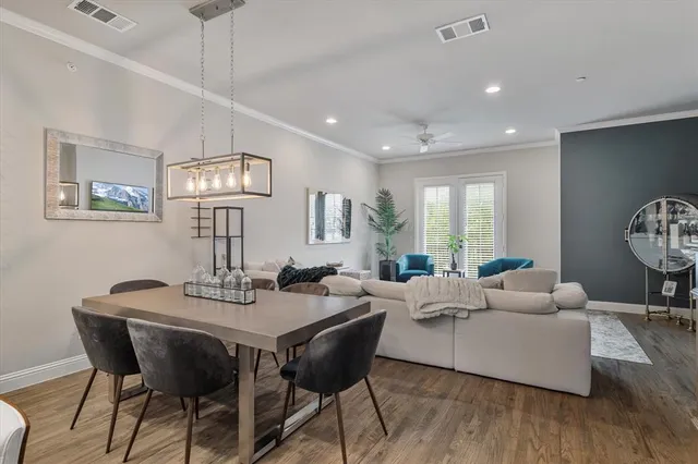 a view of a dining room with furniture a chandelier and wooden floor