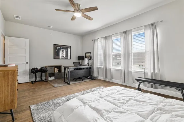 a spacious bedroom with a bed a table and a large window