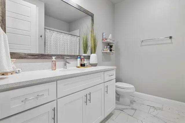 a bathroom with a sink a toilet and a mirror